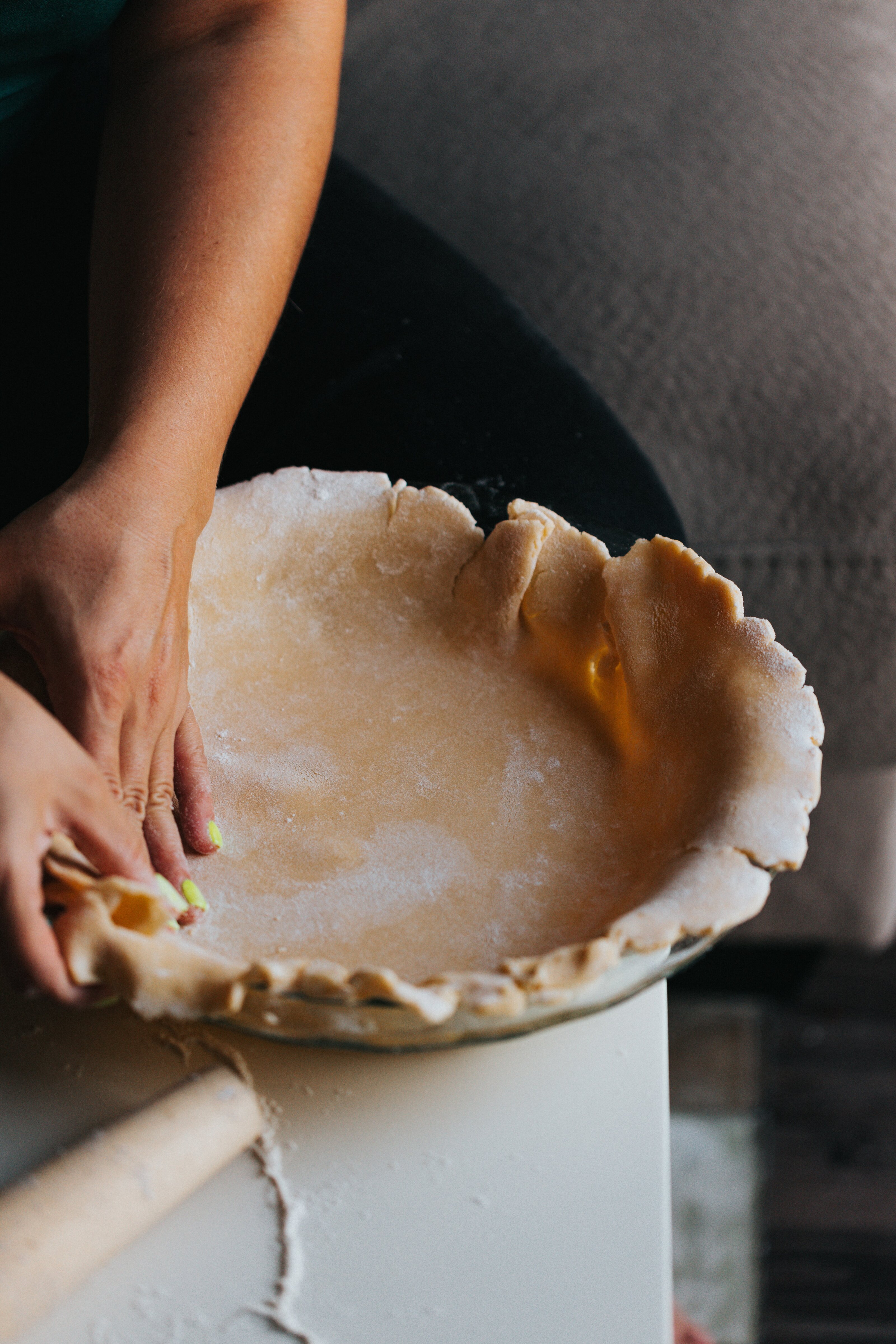 Hands crimping a pastry at the bench