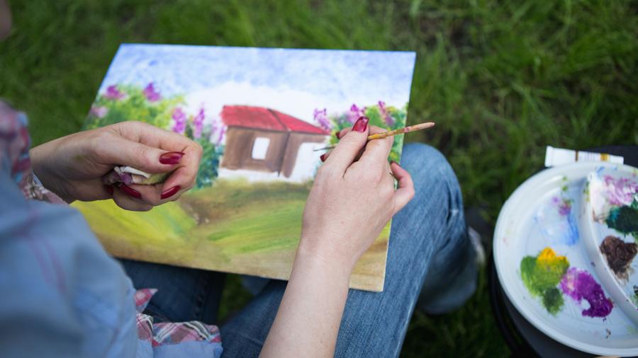 Painting a watercolour outside on the grass